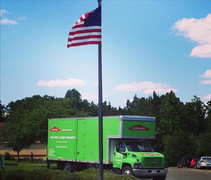 SERVPRO truck parked with an american flag in the for ground 