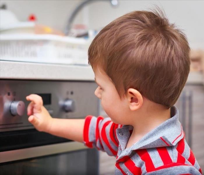 young boy attempting to touch the stove