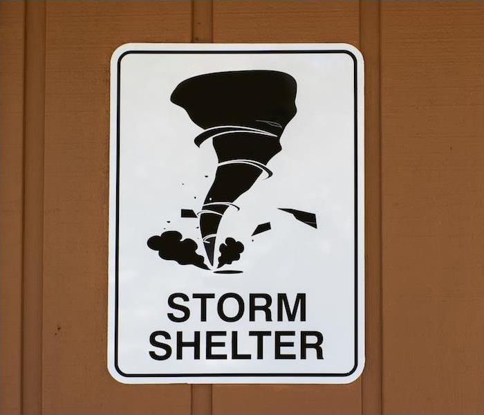 a white storm shelter sign hanging on a brown wall