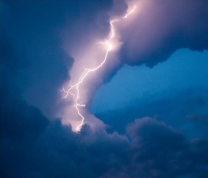 a large lightning strike in a dark blue sky